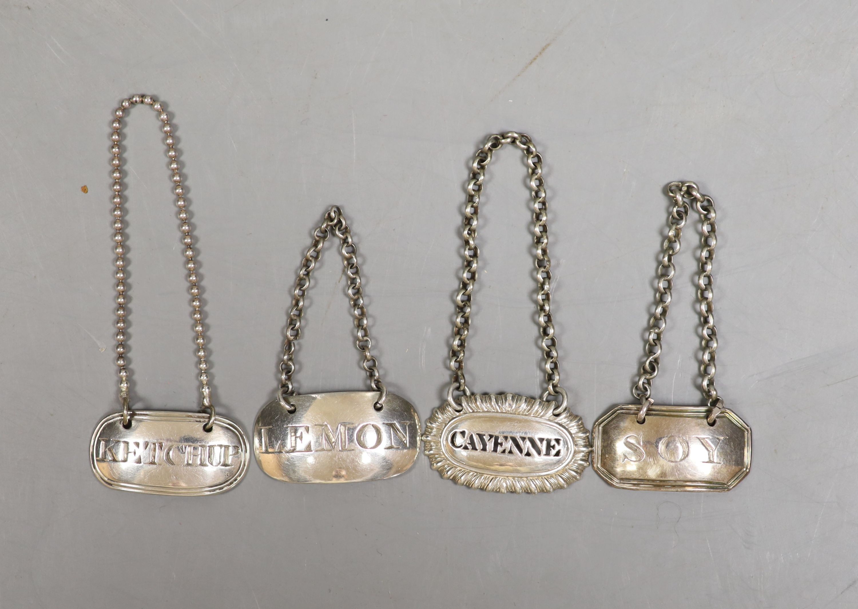 Four Georgian silver condiment labels, Soy, London, 1797, 27mm, Lemon, London, 1804, Ketchup, London, 1810 and Cayenne by Reily & Storer.